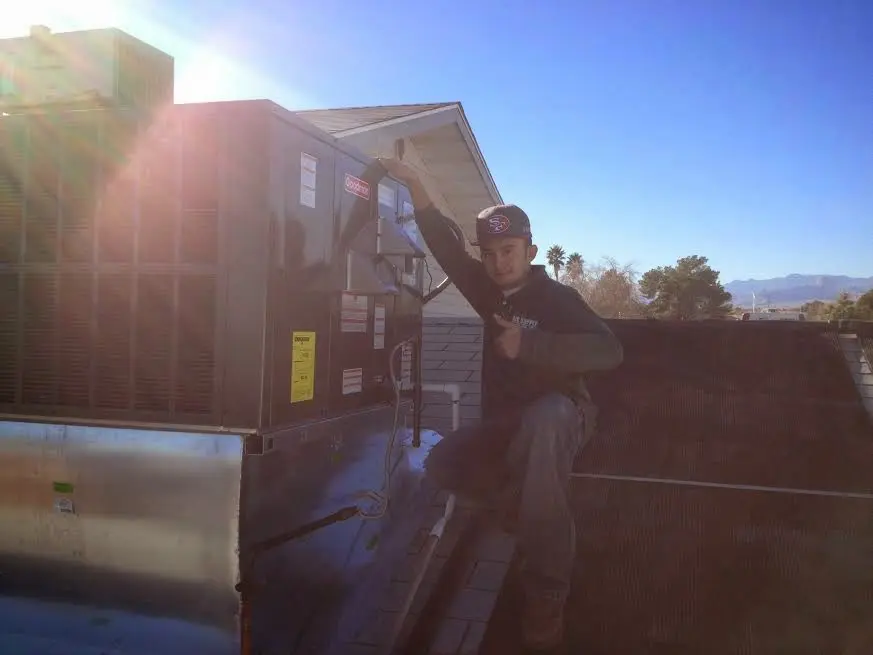 HVAC technician performing Air Duct Repair on a rooftop unit in North Hills